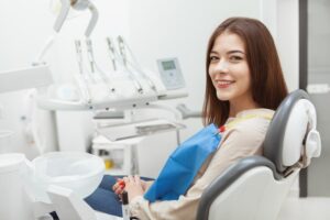 a woman sits in a dentist chair and happily awaits her drill-free dentistry 